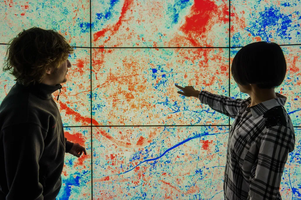 Researchers reading geospatial data on a video wall
